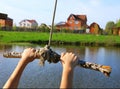 Hands hold rope swing before jump into the water on the lake and Royalty Free Stock Photo