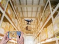 Hands hold smart phones Industrial stock storage products storage system by drone unmanned
