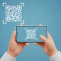 Hands holding smartphone scanning Q R code on blue background with blurred Q R code Royalty Free Stock Photo