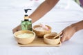 Hands Hold Spa Treatment Set with Massage oil and Sea Salt on Spa Bed Royalty Free Stock Photo