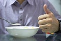 Hands hold spoon with bowl to eat cerial breakfast with thumb up Royalty Free Stock Photo