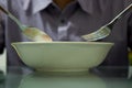 Hands hold spoon and fork with bowl to eat cerial breakfast Royalty Free Stock Photo