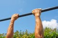 Hands hold on to the horizontal bar on the street, outdoor workout area Royalty Free Stock Photo