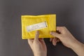 Hands hold a yellow mail bag that says RETURN TO SENDER