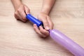 hands holding an air pump, inflate a balloon for making crafts, toys Royalty Free Stock Photo