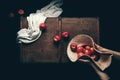 Hands holding apples in straw hat in dark background