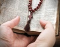 hands holding the Bible and praying with a rosary Royalty Free Stock Photo