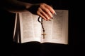 Hands holding the bible and praying with a rosary. Royalty Free Stock Photo