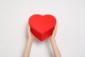 Hands holding big red box in shape of a heart. Trendy banner for Valentines Day, International Womens Day or mothers day Royalty Free Stock Photo