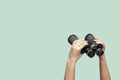 Hands holding binoculars on green background Royalty Free Stock Photo