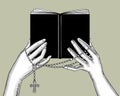 Hands holding a black book and prayer beads