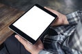 Hands holding black tablet pc with white blank screen and coffee cup on table background Royalty Free Stock Photo