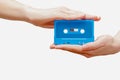 Hands holding blue cassette tape isolated in white background. Royalty Free Stock Photo