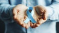 Hands Holding Blue Ribbon Symbolizing Awareness for Causes and Support Royalty Free Stock Photo