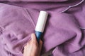 Hands holding blue sticky roller for cleaning clothes Royalty Free Stock Photo