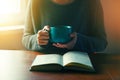 Hands holding book and reading with coffee