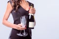 Hands holding bottle of sparkling wine and champagne flutes Royalty Free Stock Photo