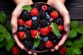 Hands holding bowl with fresh berry fruit mix