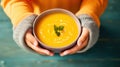 Hands holding bowl of pumpkin soup over turquoise wooden background Generative AI