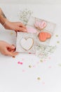Hands holding box casing with scarlet heart shaped cookie