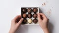 Hands holding box of chocolates on white background