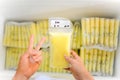 Hands holding Breast Milk Storage Bag in front of stocks in freezer Royalty Free Stock Photo