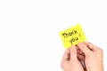 Hands holding a bright yellow thank you card note. Appreciation and gratitude concept.