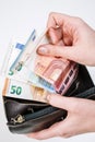 hands holding brown leather wallet full of money - various Euros Eur banknotes