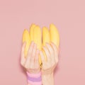 Hands holding bunch of bananas. Fashion, vanilla style minimalis Royalty Free Stock Photo