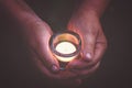 Hands holding burning candle in the dark, prayer and spirituality concept Royalty Free Stock Photo