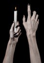 Hands holding a candle, a candle is lit, black background, solitude, warmth, in the dark, Hands death, hands witch Royalty Free Stock Photo