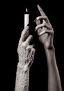 Hands holding a candle, a candle is lit, black background, solitude, warmth, in the dark, Hands death, hands witch Royalty Free Stock Photo