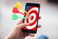 Person Holding Cellphone With Darts On Target Royalty Free Stock Photo
