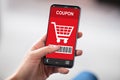 Man`s Hand Holding Mobile Phone With Shopping Coupon