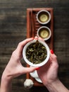 Hands holding Chawan tea bowl with green oolong Royalty Free Stock Photo