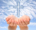 Hands holding Christian cross with light beams Royalty Free Stock Photo