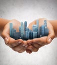 Hands holding city over gray concrete background