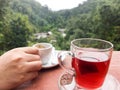 Hands holding coffee cups and Resting on a glass of tea on the t