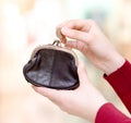 Hands holding coin and retro styled money pouch in Royalty Free Stock Photo