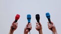 Hands holding colorful microphones for press conference or interview white background Royalty Free Stock Photo