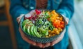 Hands holding a colorful poke bowl.