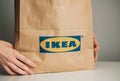Hands holding craft paper shopping bag with IKEA logo Royalty Free Stock Photo