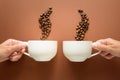 Hands holding cup of coffee with smoke from coffee beans brown paper background. Royalty Free Stock Photo