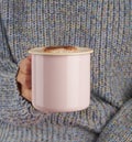 Hands holding cup of hot chocolate, gray cozy sweater, beautiful pink manicure, home style, autumn morning, close up