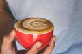 Hands holding cup of hot coffee latte with heart shaped foam art. Royalty Free Stock Photo