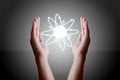 Hands holding and cupping a glowing atom Royalty Free Stock Photo