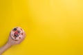 Hands holding cups with different rolled ice cream on bright yellow background Royalty Free Stock Photo