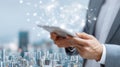 Businessman holding tablet connecting to global network and smart city, worldwide and business symbolizing communication Royalty Free Stock Photo