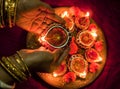 Hands holding Diwali lamps