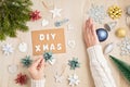 Hands holding DIY, zero waste, eco friendly Christmas ornaments on wooden background vs industrial plasic decoration Royalty Free Stock Photo